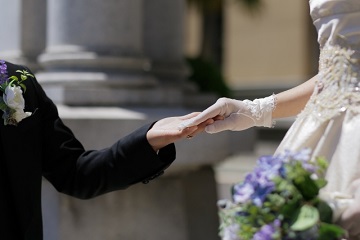 教会でブーケを持った花嫁の手を握る花婿