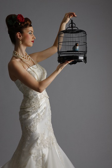 ブライダルドレスを着て鳥かごを持つヘアメイクモデル