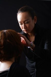 モデルにメイクするメイクアップアーティスト